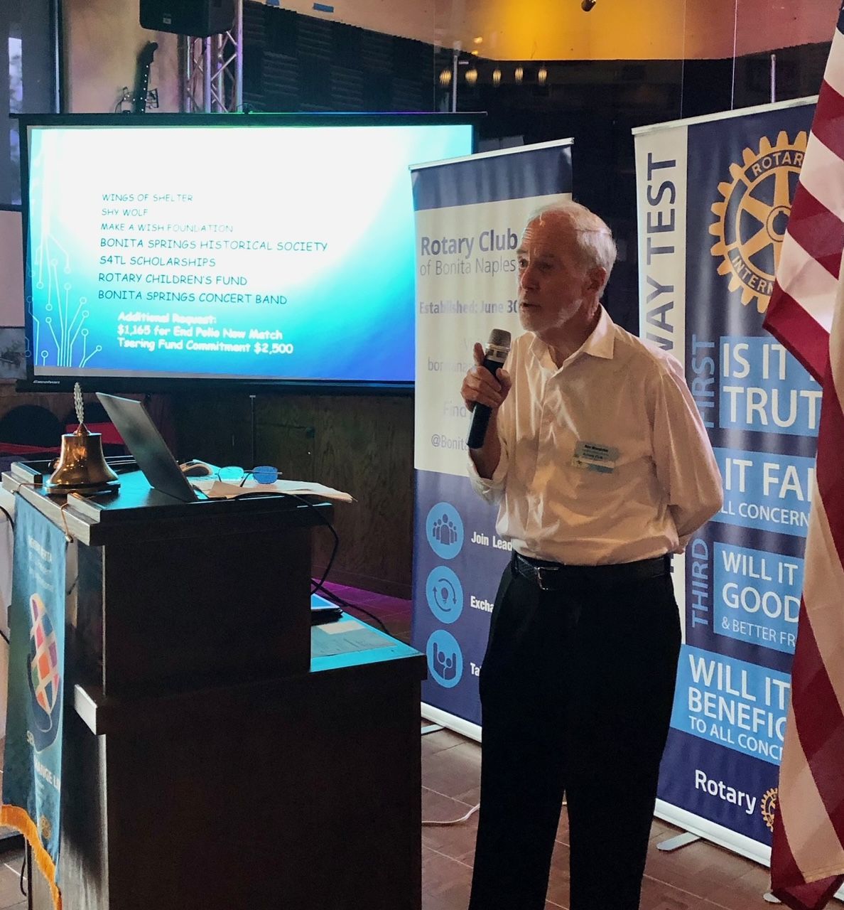 A man giving a presentation in front of a sign that says way test