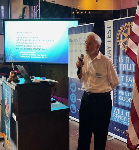 A man giving a presentation in front of a sign that says way test