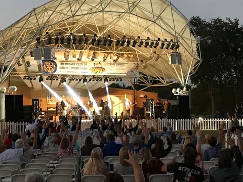 A crowd of people are watching a band on a stage