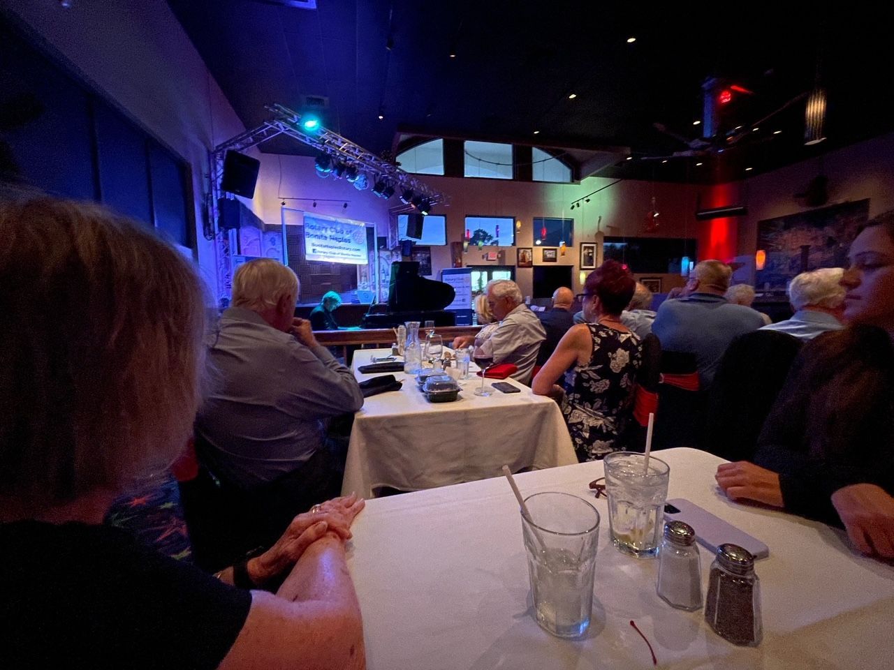 A group of people are sitting at tables in a restaurant watching a show.