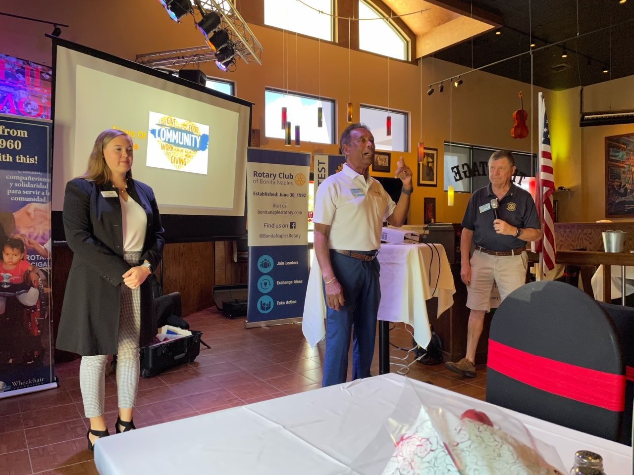 A group of people standing in front of a projector screen in a room.