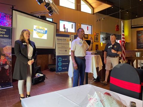 A group of people standing in front of a projector screen in a room.