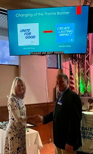 Two people stand by a conference booth with a blue banner showing UNITE FOOD and CREATE A LASTING IMPACT.