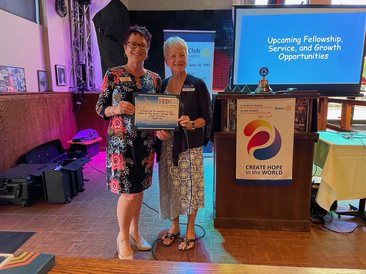 Two women are standing next to each other holding a certificate.