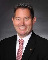 A man in a suit and tie is smiling for the camera.