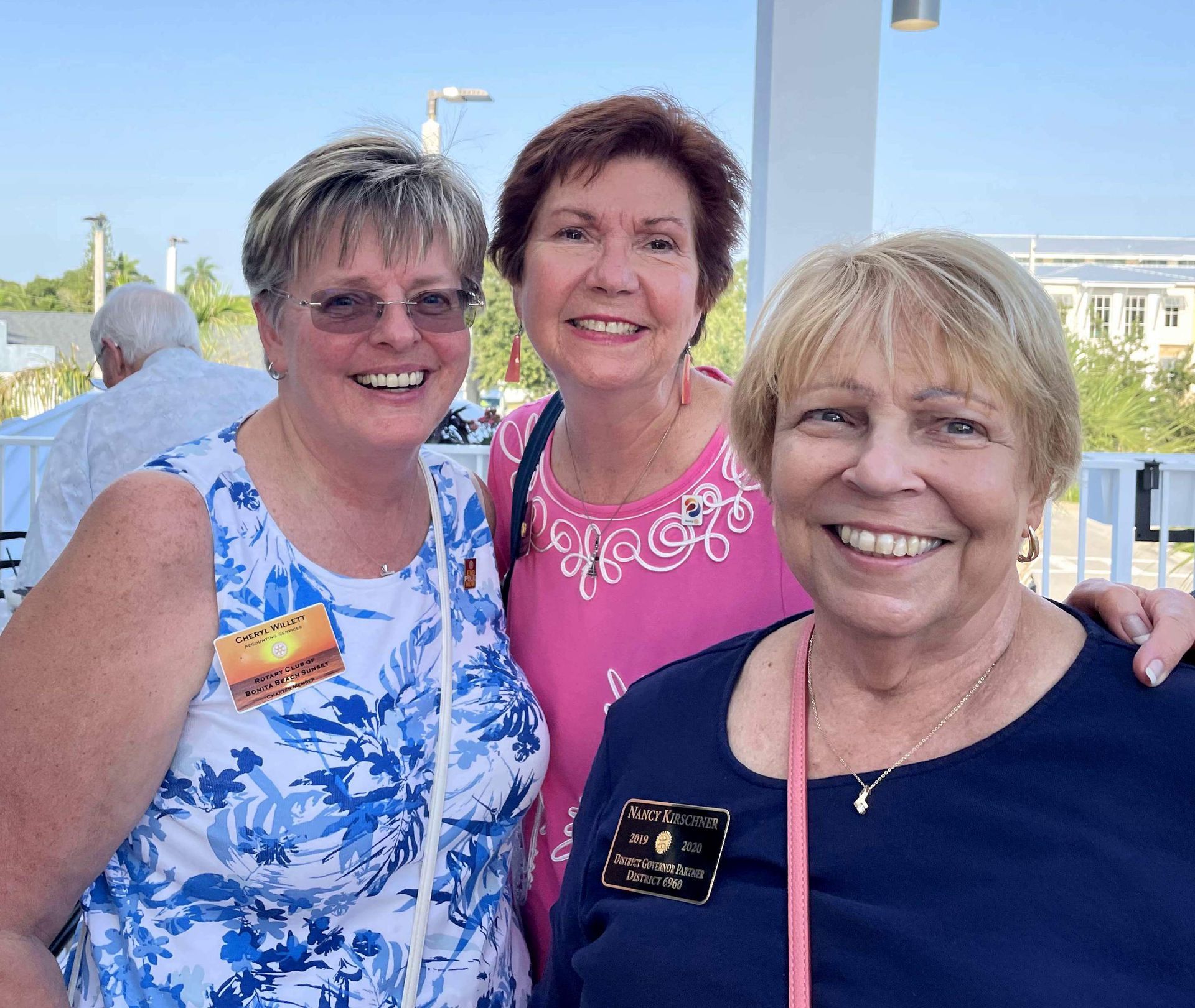 Three older women are posing for a picture and one of them has a name tag that says sandra