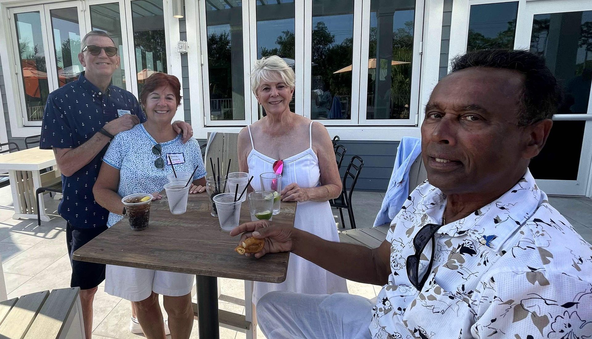 A group of people are standing around a table with drinks.