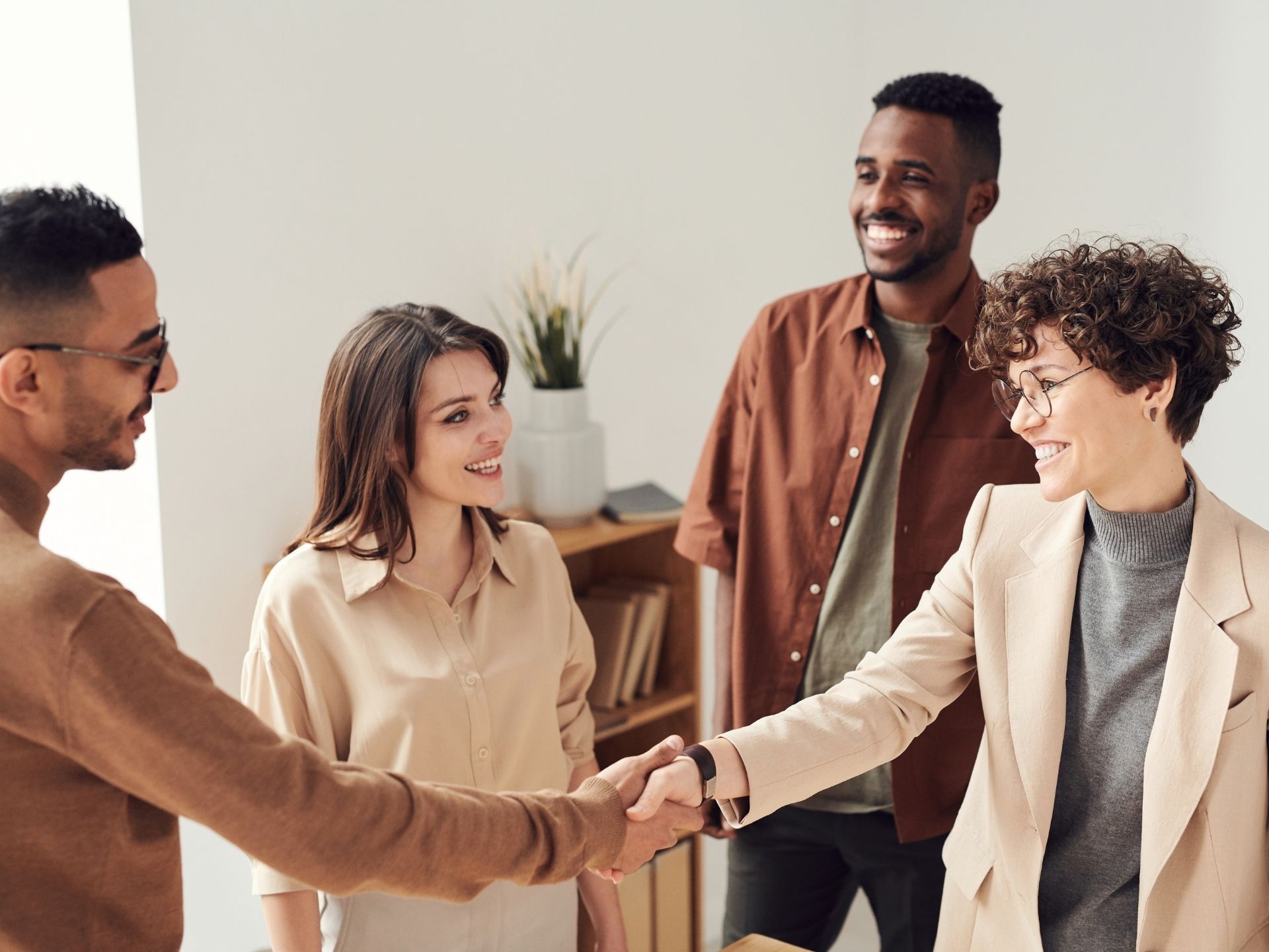 A group of people are shaking hands in a room.