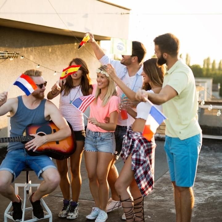 A group of people standing around a man playing a guitar