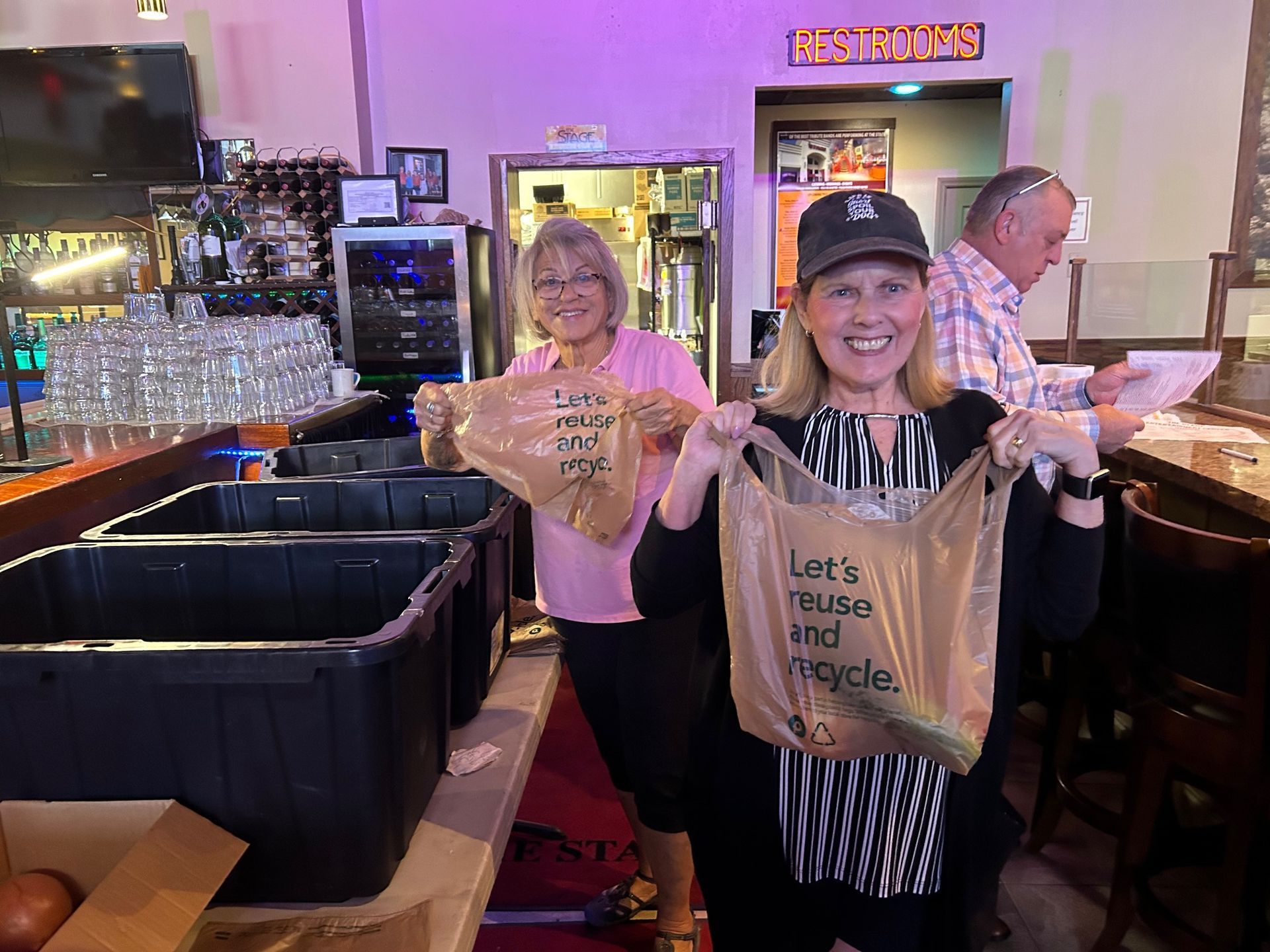 A woman is holding a bag that says let 's music and recycle.