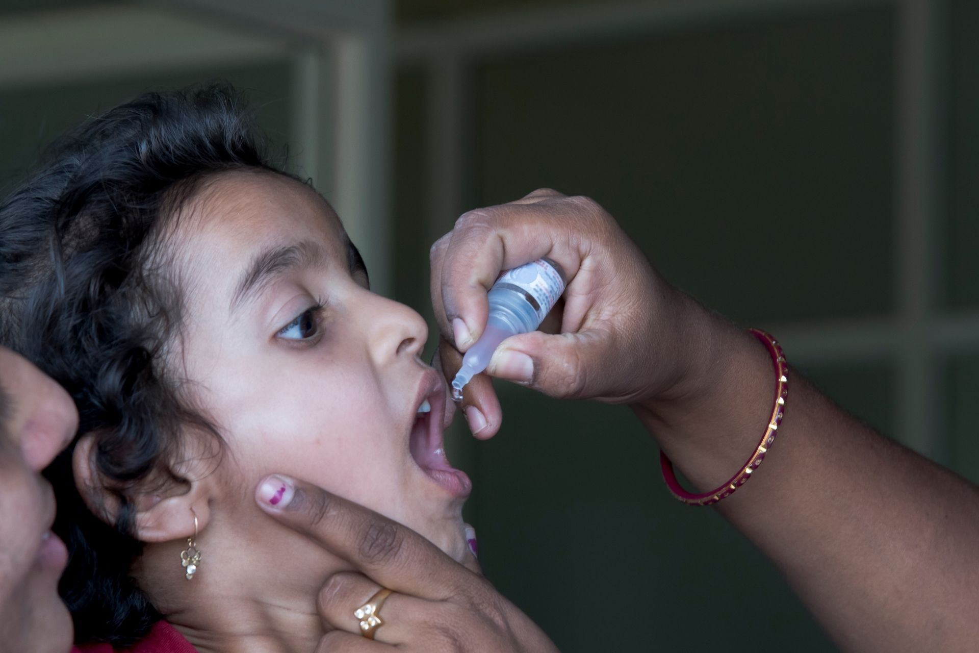 A little girl is getting a vaccine from a woman.