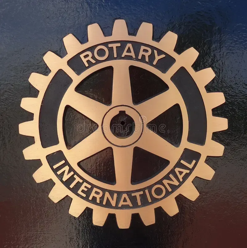 A gold rotary international logo on a black background