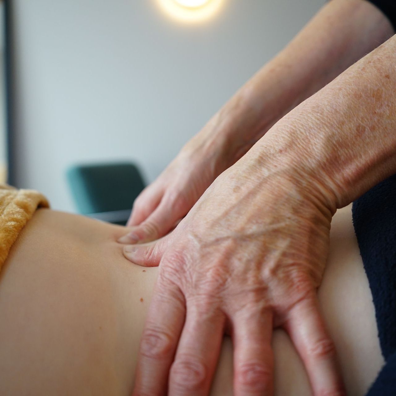 Handen die de onderrug masseren, voor therapeutische doeleinden.
