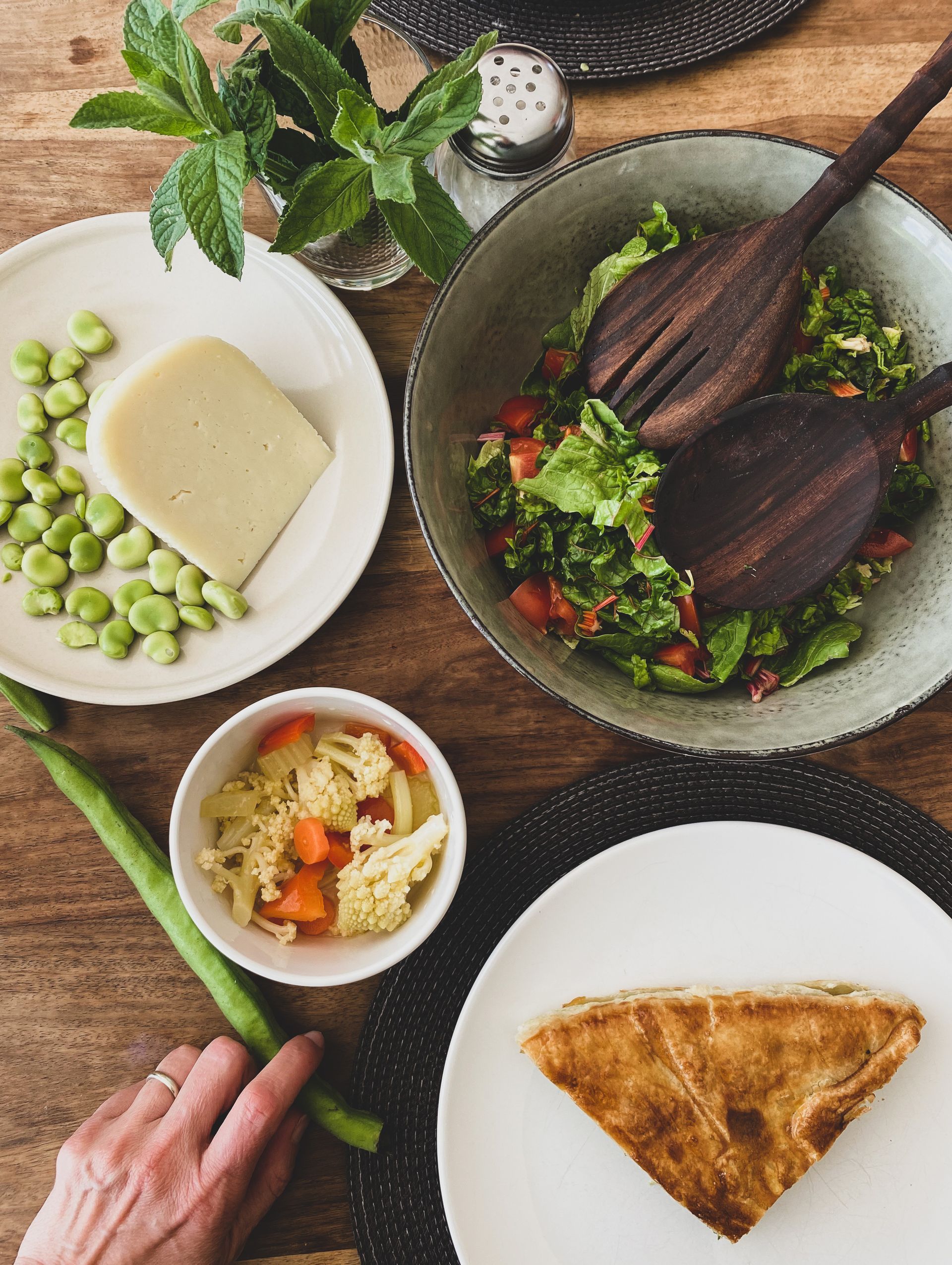 Overhead view of a table with a salad, side dishes, and a piece of pie.