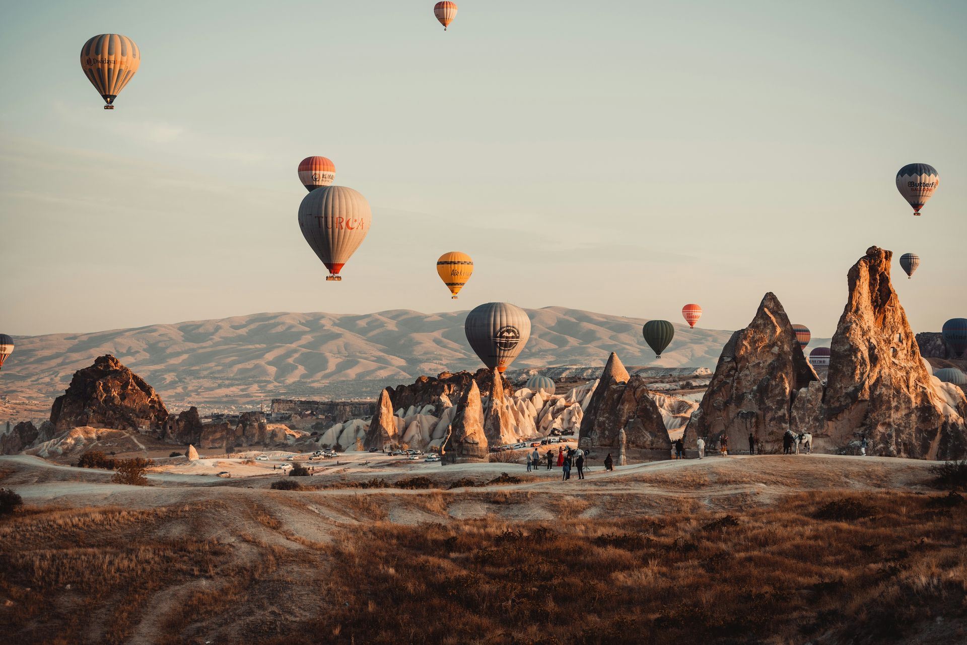 Hot air balloons over Cappadocia's rock formations at sunrise.