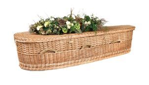 Wicker casket with a floral arrangement on top