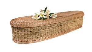 Long woven wicker casket with a hinged lid and white flowers on top