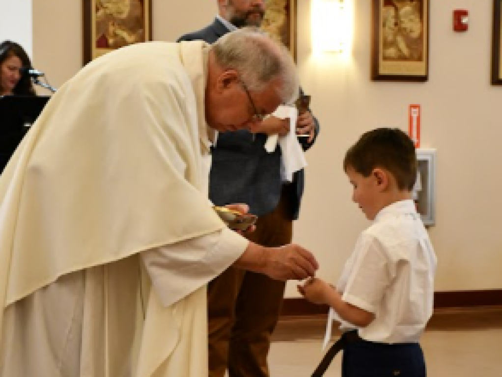 Father Paul giving first communion
