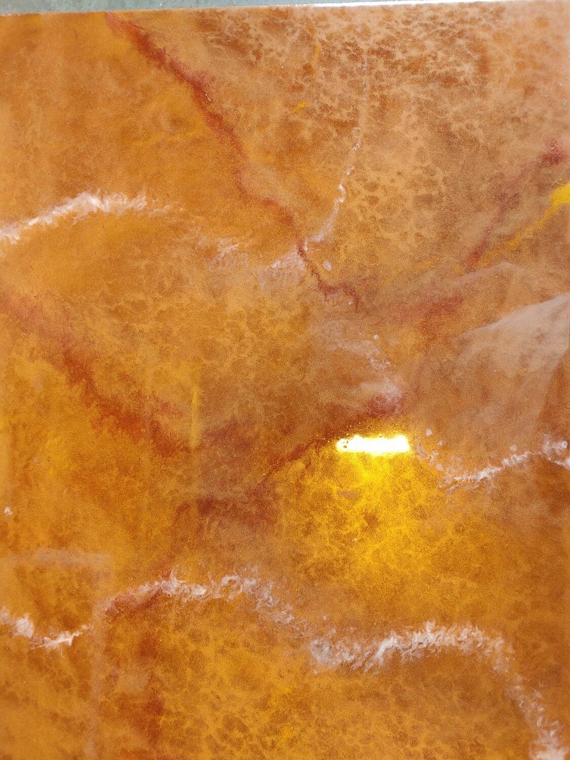 Close-up of a crumpled orange-brown textured surface with a small bright yellow highlight.