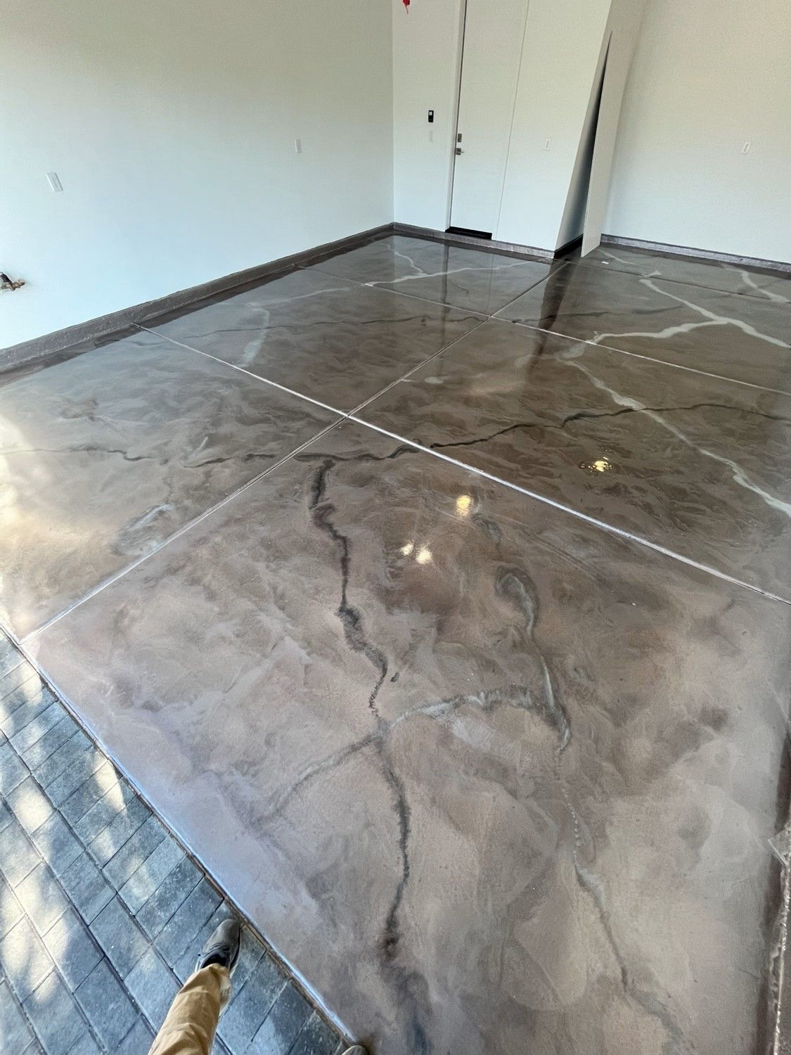 Empty room with glossy gray marble tile floor and white walls