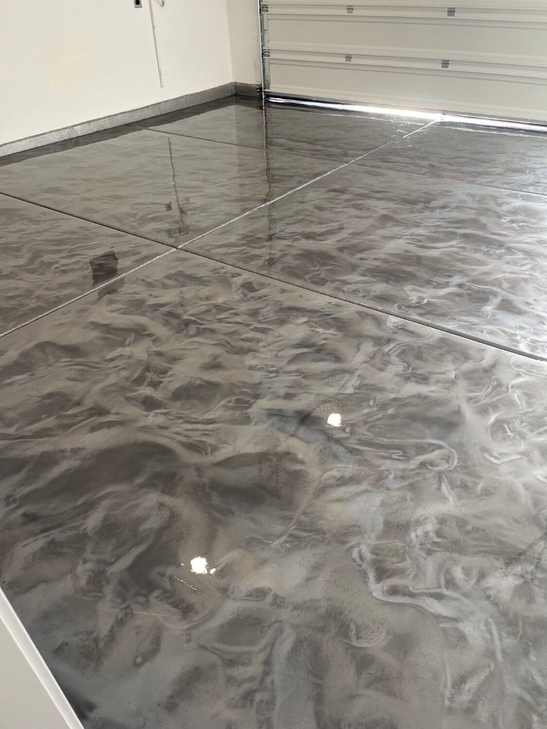 Glossy gray marble floor tiles in a room corner near a doorway