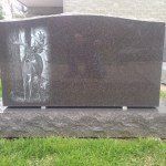 A gravestone with a picture of a man riding a horse on it.