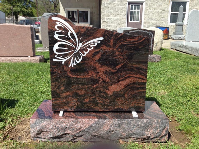 A gravestone with a butterfly on it in a cemetery