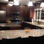 There is a bowl of oranges on the counter in the kitchen.
