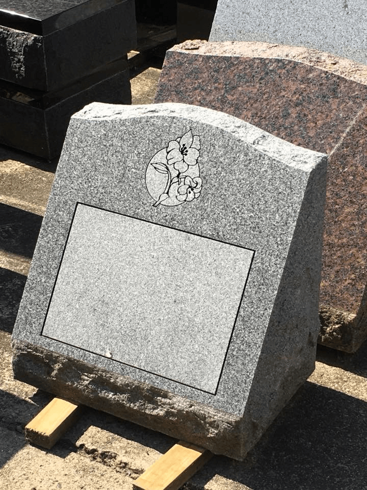 A gravestone is sitting on top of a wooden pallet in a cemetery.