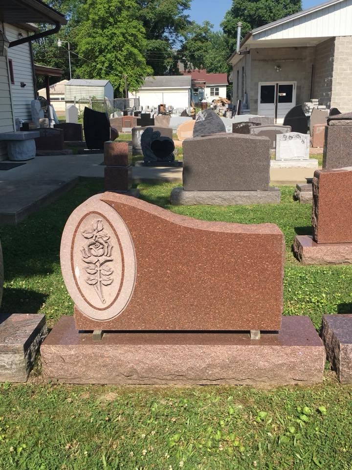 A gravestone in a cemetery with a tree on it