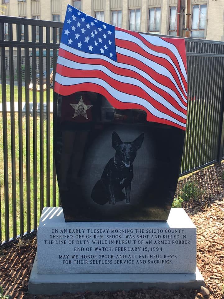 A memorial with a picture of a dog and an american flag
