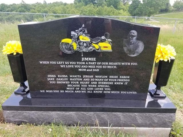 A black gravestone with a picture of a motorcycle on it