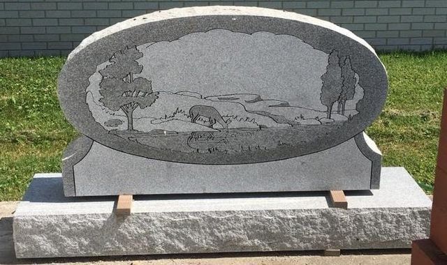 A gravestone with a picture of trees on it