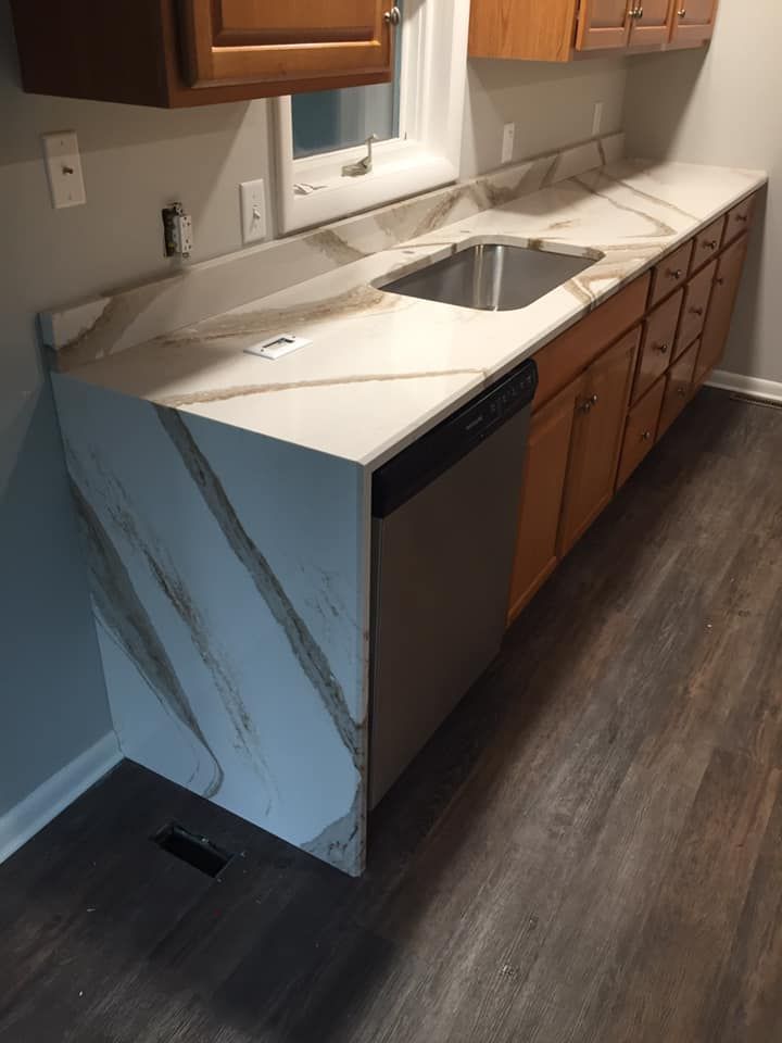 A kitchen counter with a sink and a dishwasher