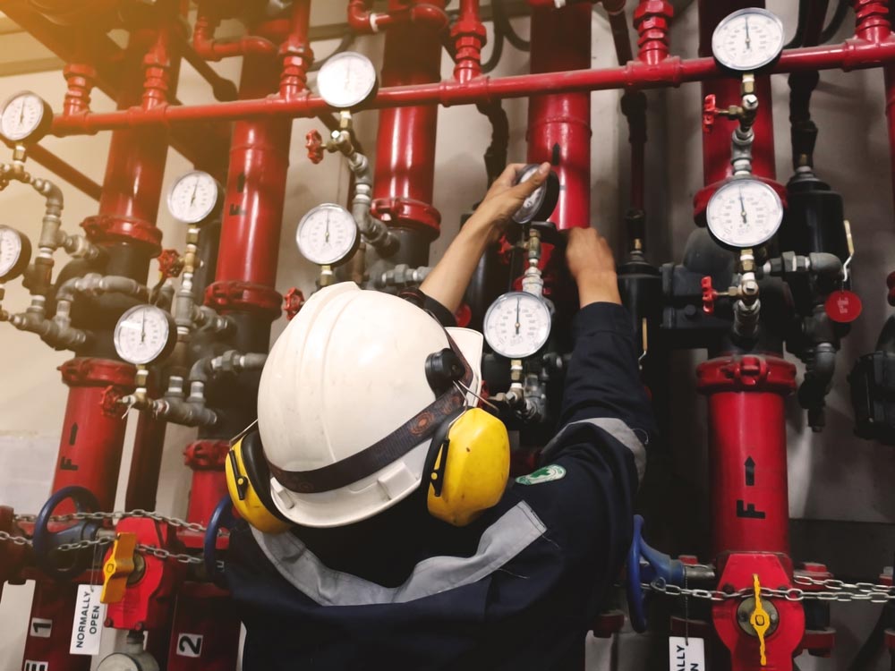 Maintenance Man Repairing The Pipe Of Fire Hose — Hunter Fire & Safety in Edgeworth, NSW