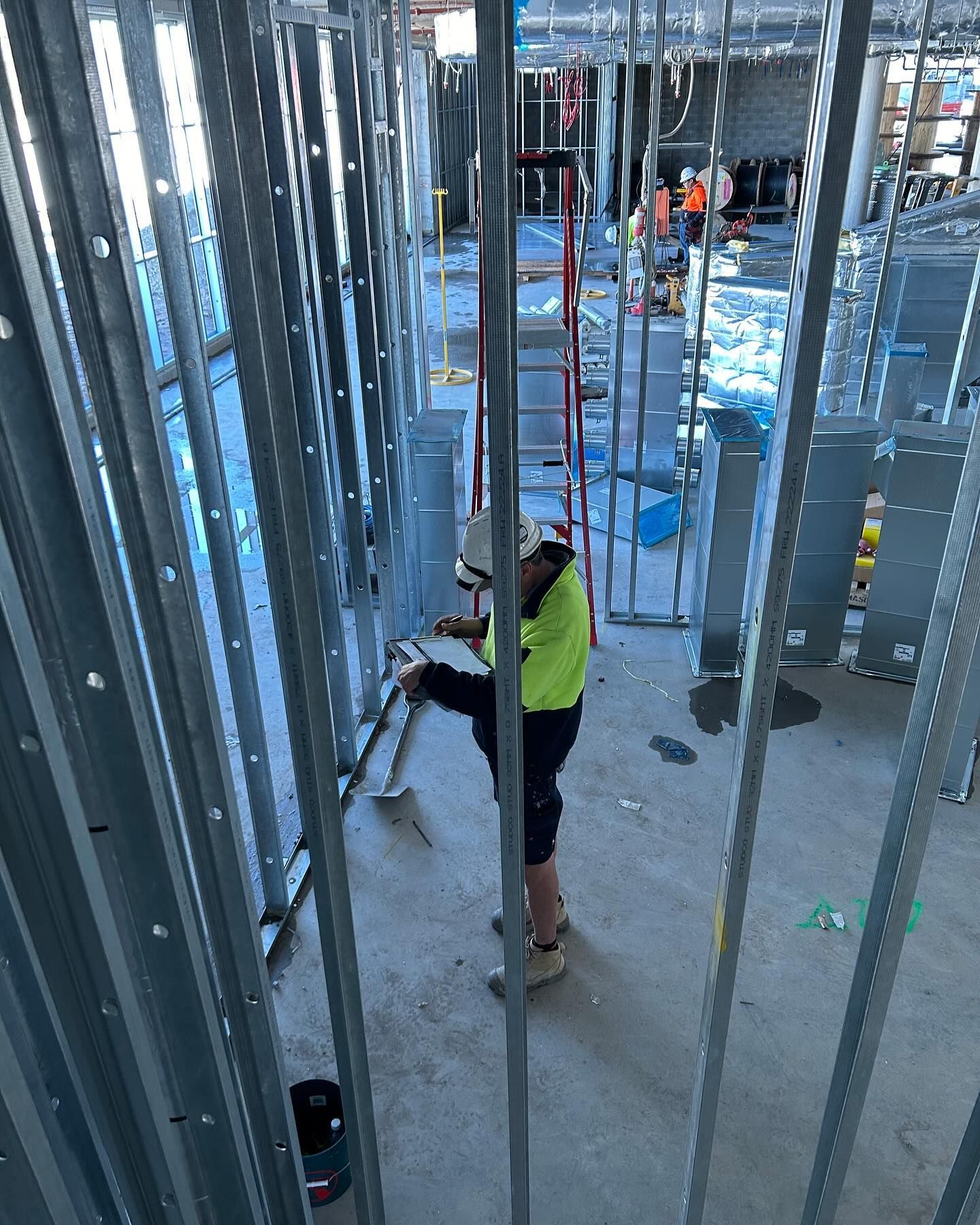 Construction Worker in Safety Gear Inspects a Wall Framework — Hunter Fire & Safety in Edgeworth, NSW