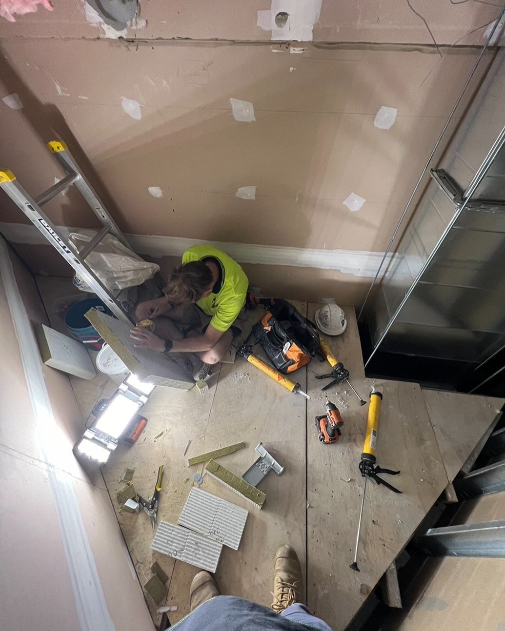 Person in a Construction Setting Working on Walls — Hunter Fire & Safety in Edgeworth, NSW