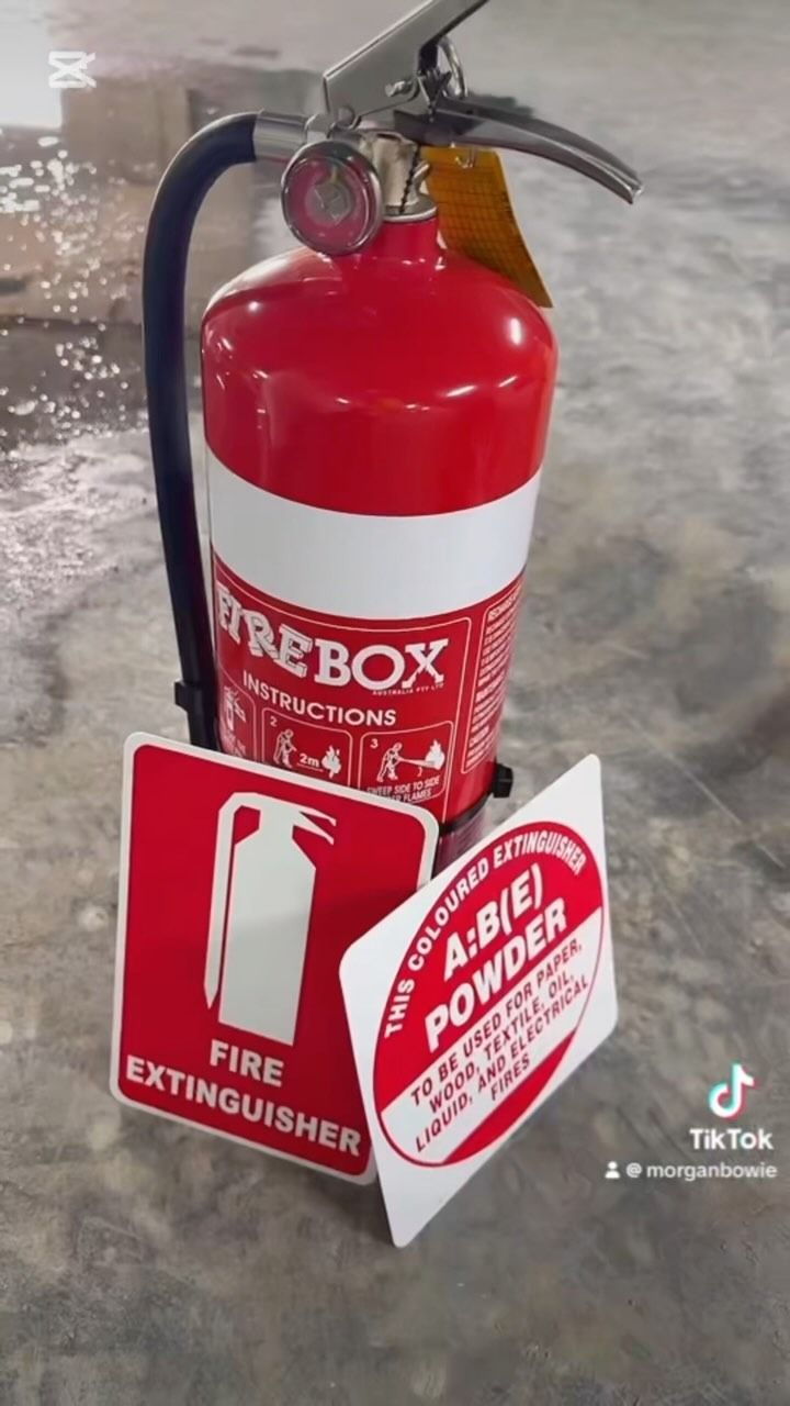 Fire Extinguisher With Signage on a Concrete Floor — Hunter Fire & Safety in Coffs Harbour, NSW