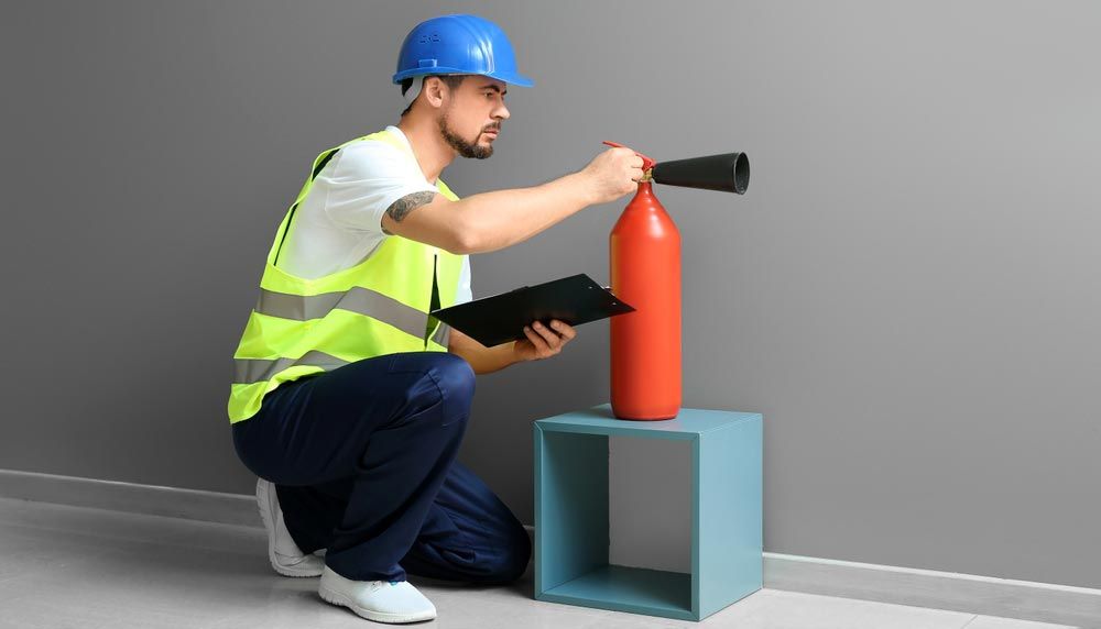 Fire Safety Specialist Inspecting Extinguisher — Hunter Fire & Safety in Port Stephens, NSW