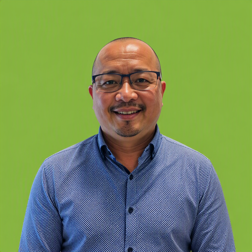 A man wearing an orange vest is standing in front of a green background.