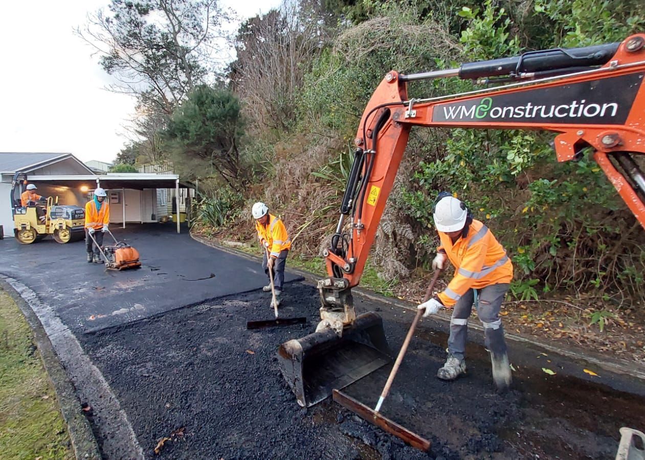 A group of construction workers are working on a road.
