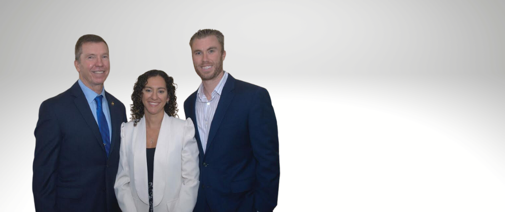Three professionals in business attire posing against a white background