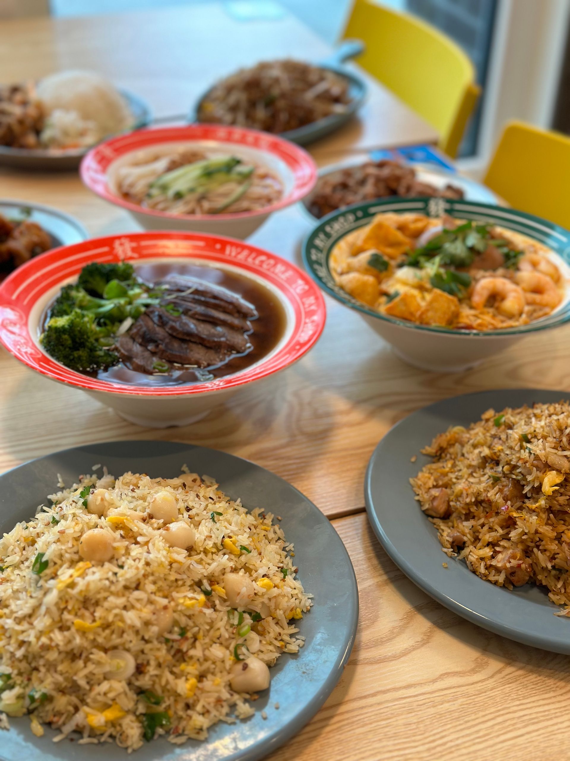 Assorted Japanese dishes in colorful bowls and plates on a wooden table
