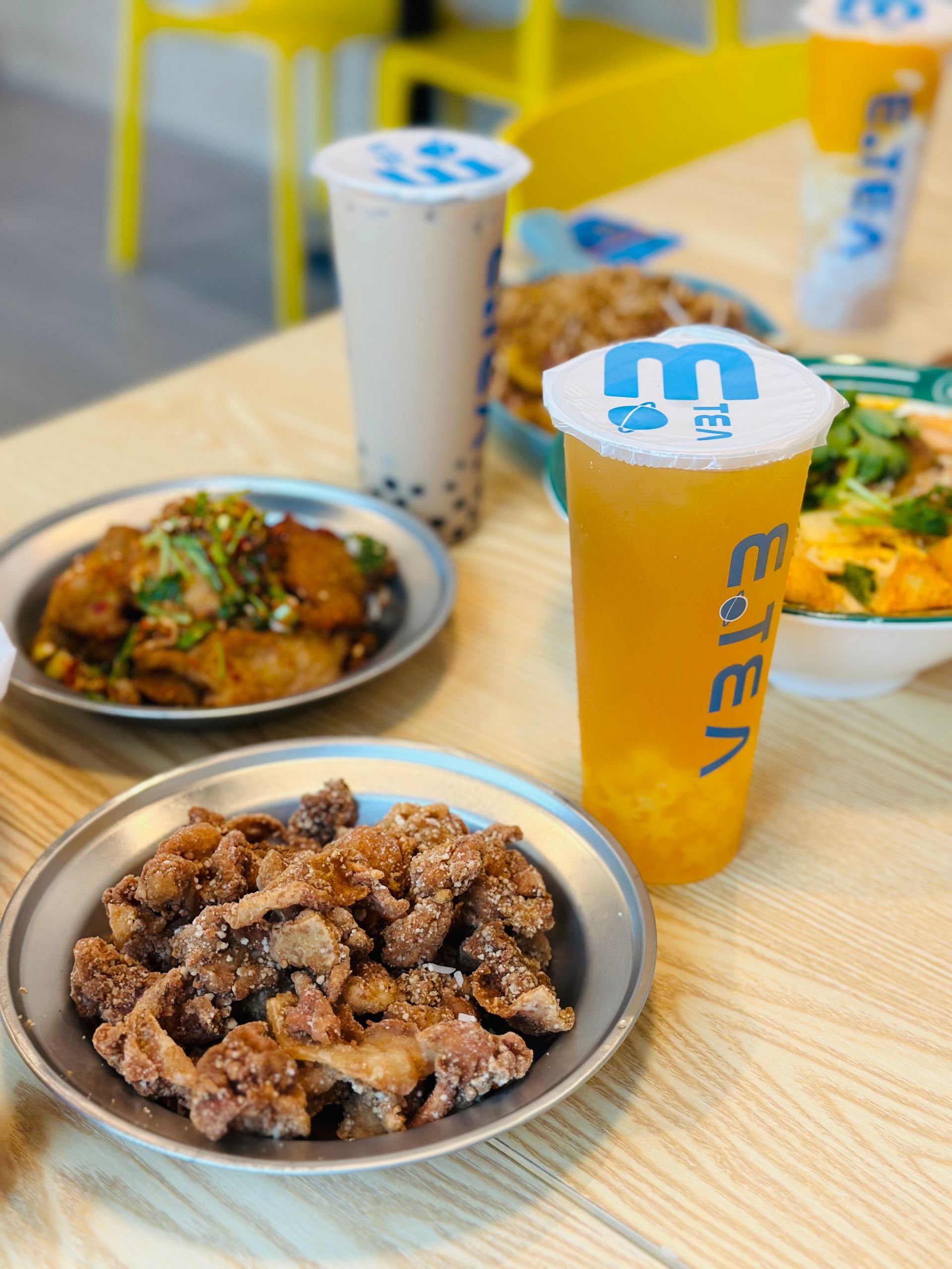 Fast-food meal on a table with fried chicken, side dishes, and two drinks