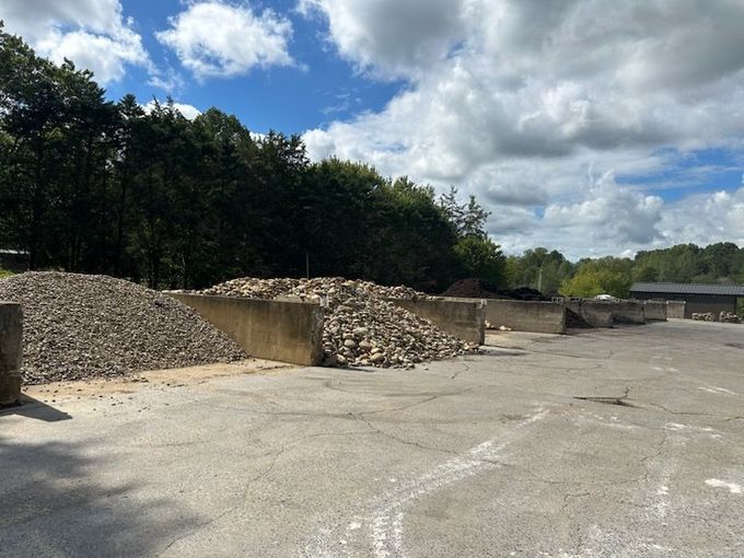 Pile of large, rough boulders stacked outdoors under a clear blue sky