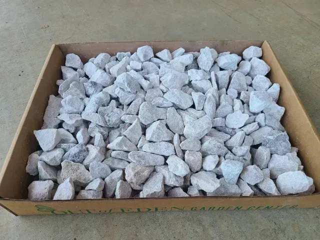 Cardboard box filled with small white rocks or gravel chips