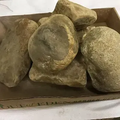 A box of dusty, irregularly shaped rocks stacked together.