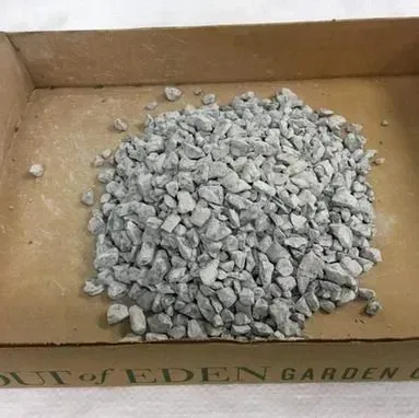 A cardboard box filled with a pile of small gray gravel stones.