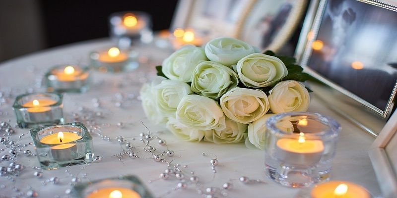 White roses, candles, and framed photos on a memorial table at a Seattle funeral home