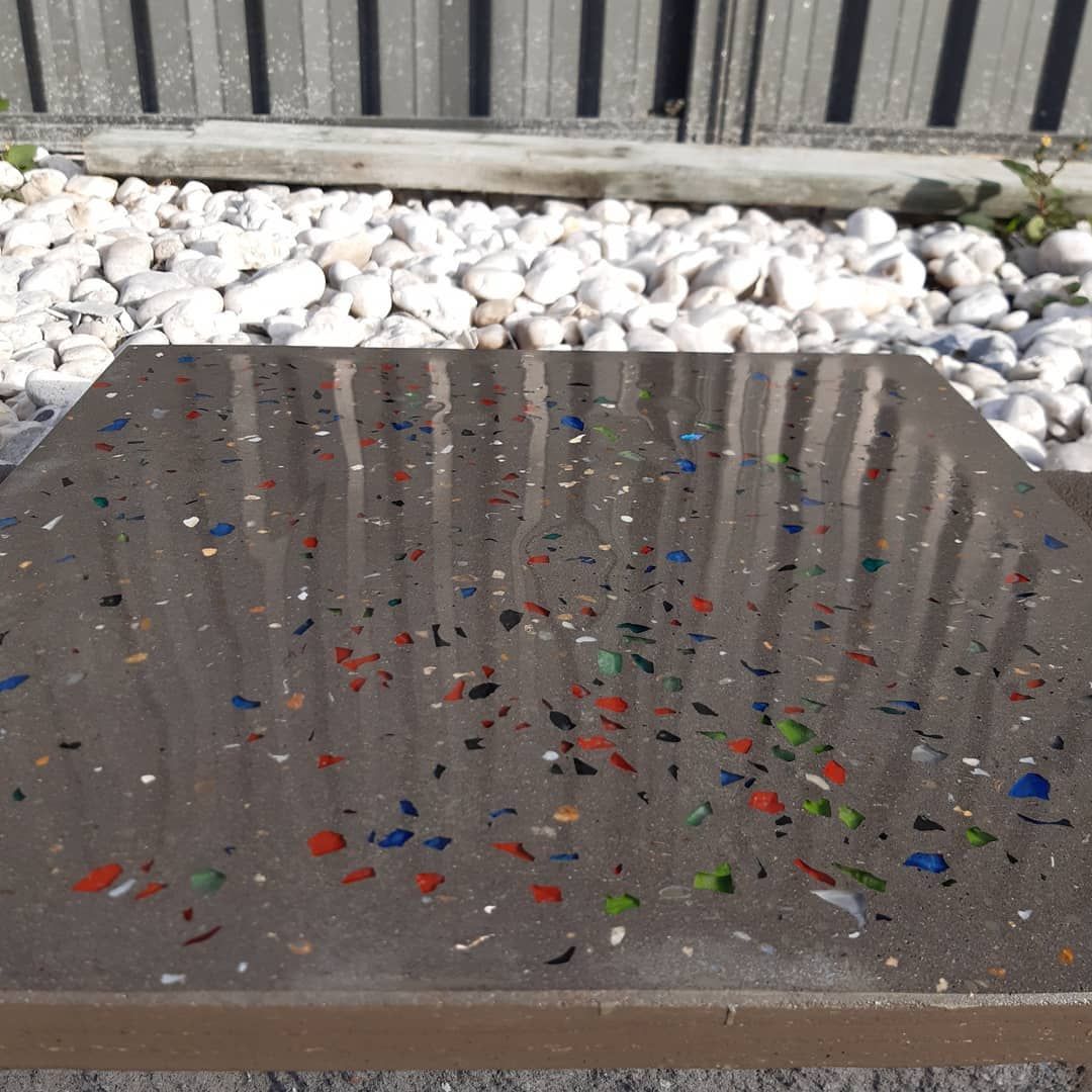 A Square, Glossy Brown Paving Tile Embedded With Small, Colourful Shards of Glass — JDB Concreting in Horsley, NSW
